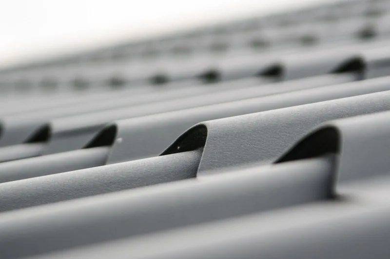 Close-up of grey corrugated roof sheeting showing the shallow wave profile and fixings