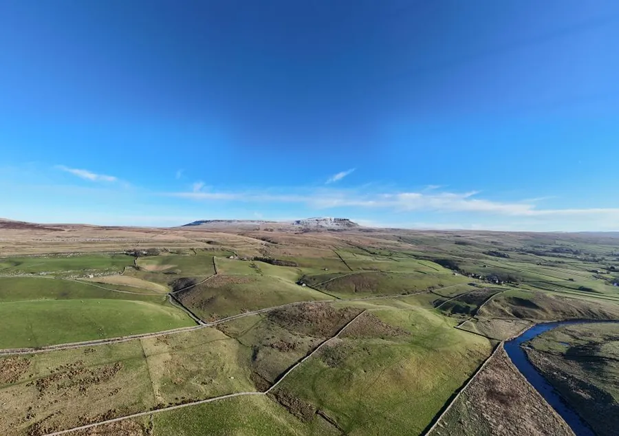 Yorkshire Dales landscape of drystone-walled fields rising to open moorland
