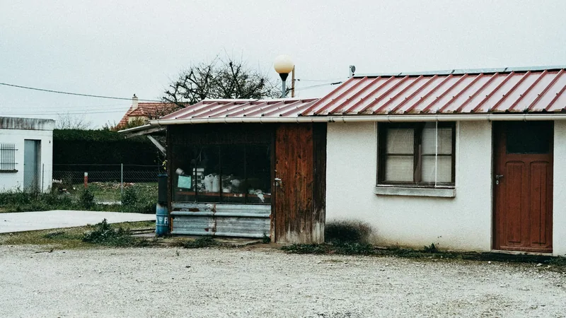 Weathered outbuilding with an ageing sheet roof showing its condition