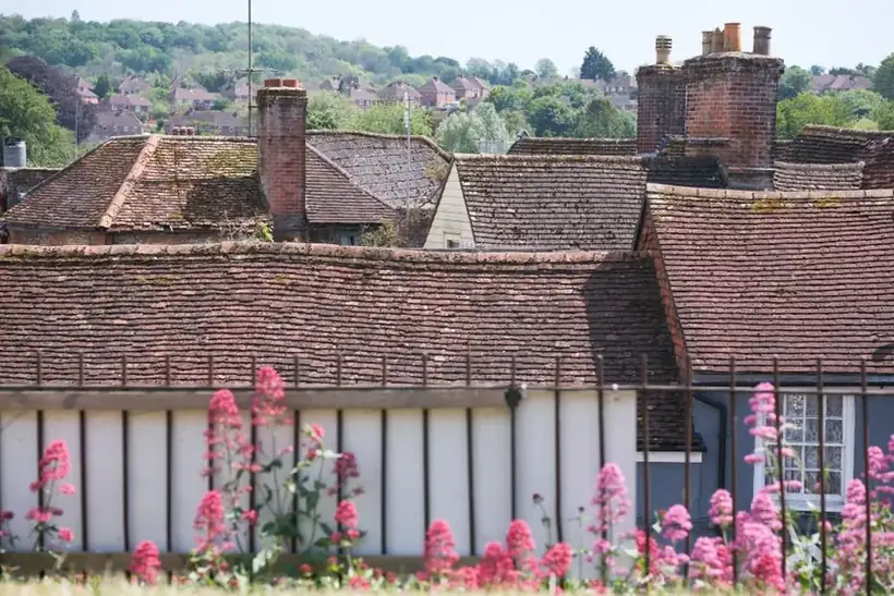 English village roofscape of old clay tiled roofs and brick chimneys at varying angles