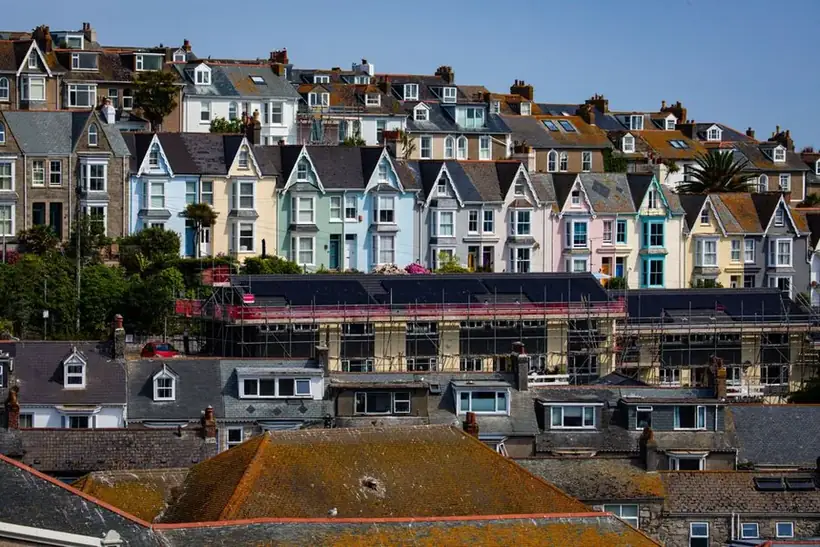 British terraced houses on a hillside with scaffolding erected across a slate roof