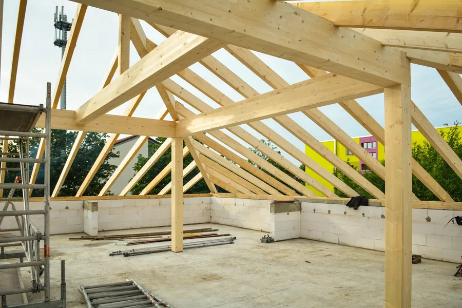 Roof stripped back to timber structure with open sky visible through the rafters