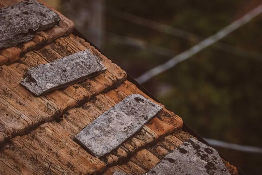 A cracked and split length of old lead flashing on a roof