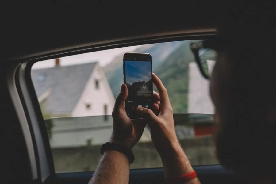 A homeowner photographing roof damage to document an insurance claim