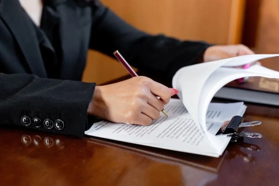 Person signing and reviewing legal lease documents relating to a property