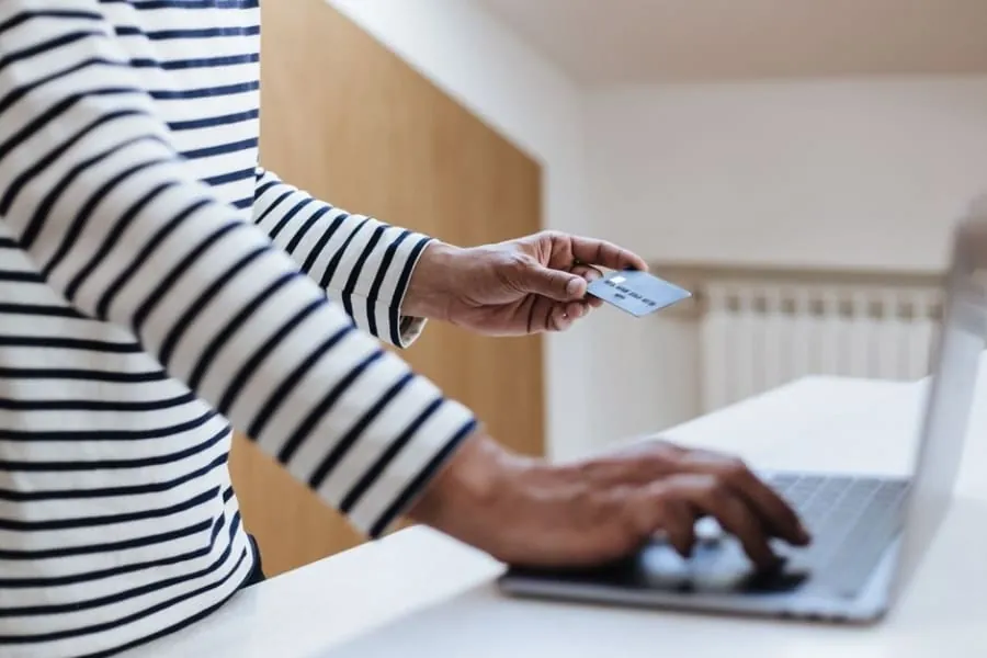 Person entering credit card details on a laptop to pay a roofing deposit