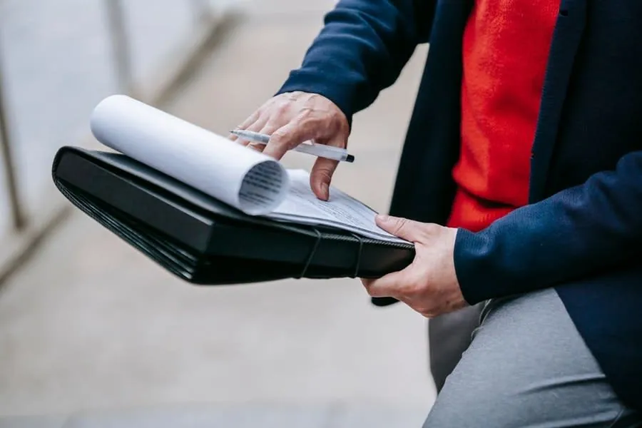 Comparing roofing quotes and plans held in a folder