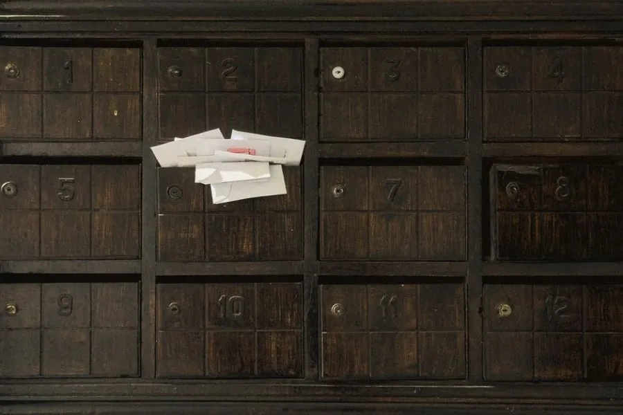 Letters and notices in numbered mailbox slots at a block of flats