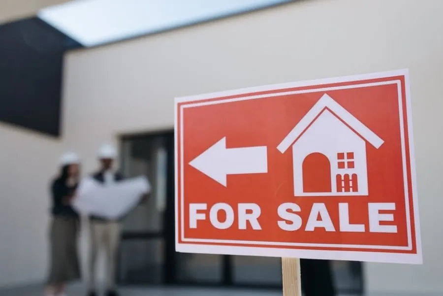 A For Sale sign outside a period house with a slate roof