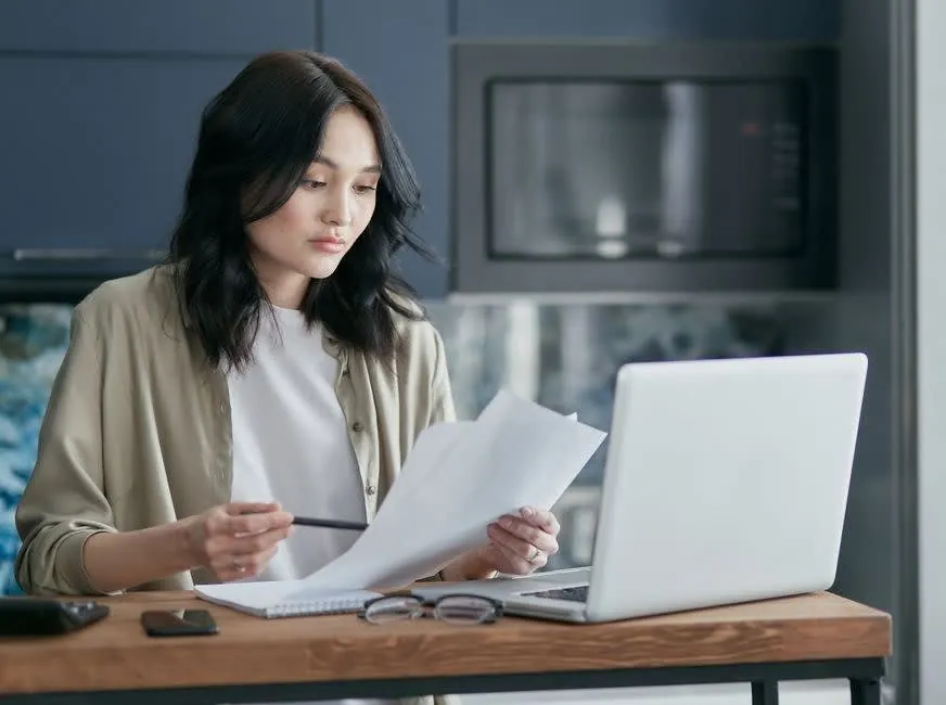 Homeowner reading through home improvement documents at a kitchen table