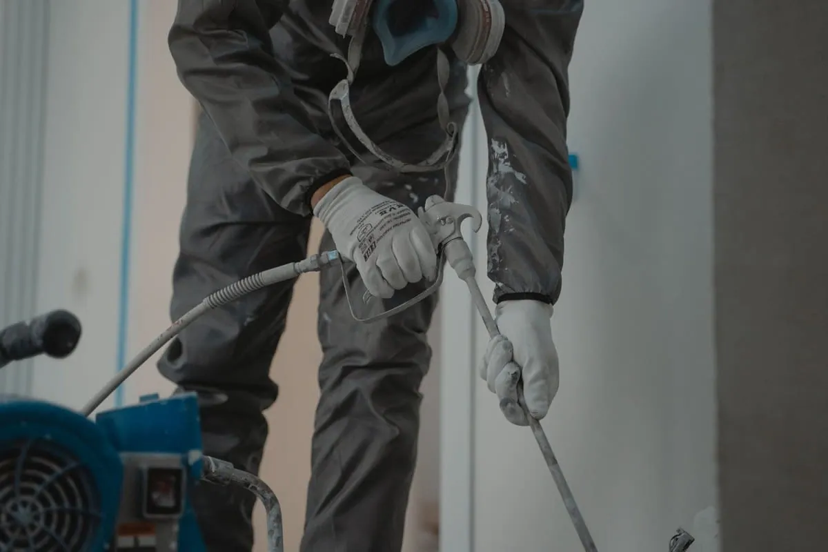 A roof being sprayed with a coloured coating over the existing tiles