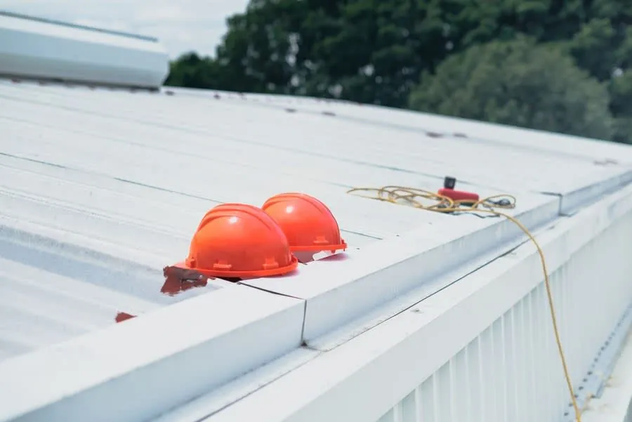 A roofer carrying out routine maintenance and gutter clearing