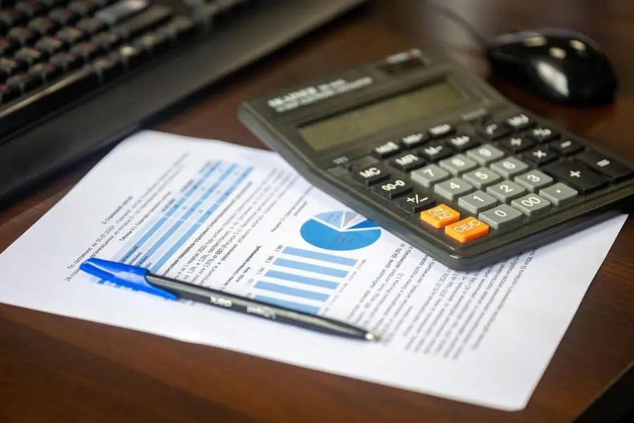 Roofing quote paperwork on a desk with a calculator
