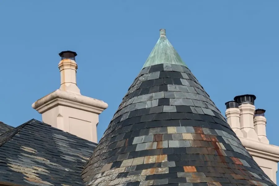 A close-up of slipped and cracked slates on a pitched roof