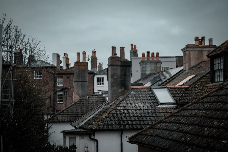 Rooftops and chimneys of old brick houses under an overcast sky