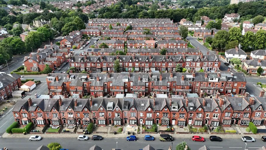 A Victorian terraced roofline with chimneys running along the street
