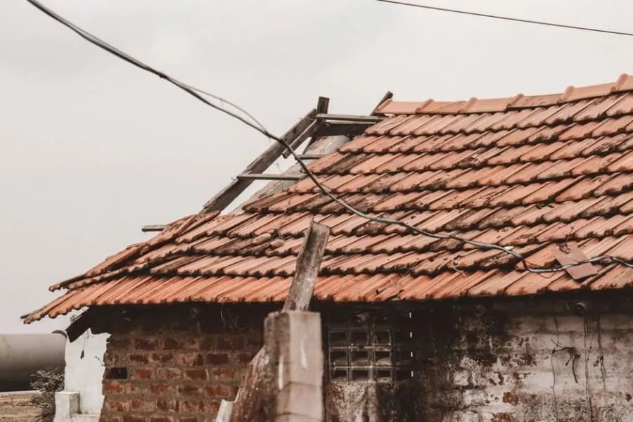 Wind lifting and displacing roof tiles during a storm